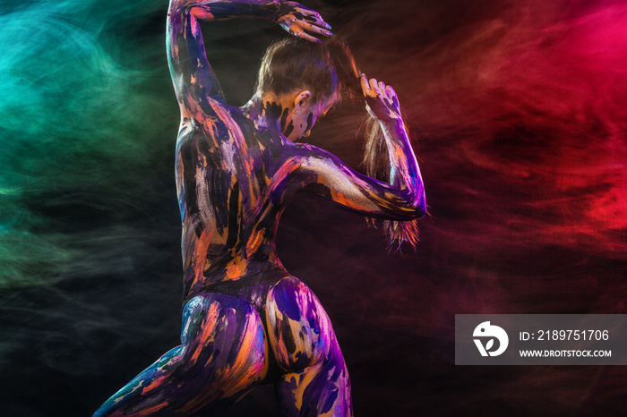 Young woman painted different colors. Inspired dance to music. Body art colorful. An amazing woman w