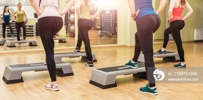 Group of women making step aerobics from the backside