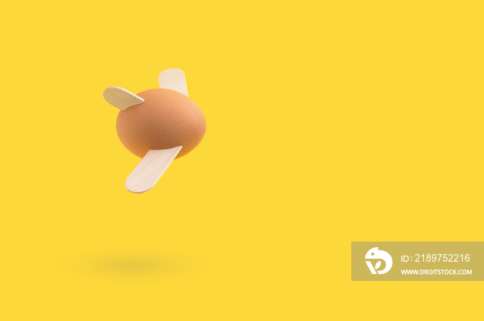 Minimal Easter concept with flying egg on yellow background