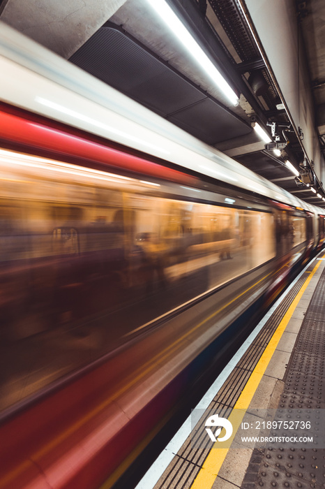 Motion blurred moving train on London Underground tube station