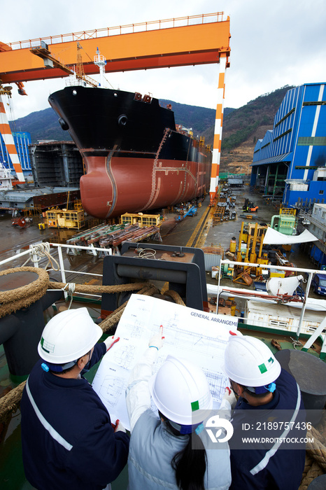 Workers looking at plans at shipyard, GoSeong-gun, South Korea