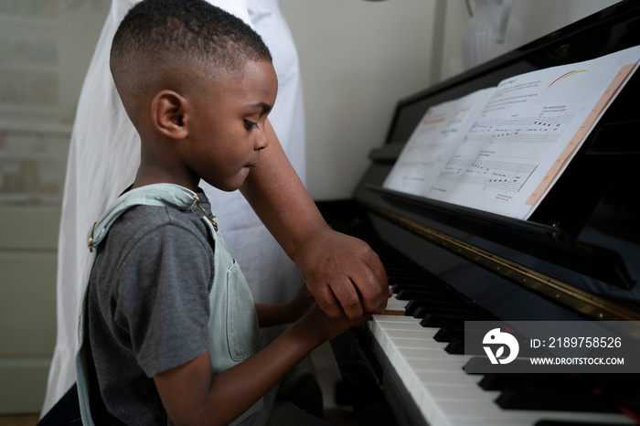 Mother and son (4-5) playing piano