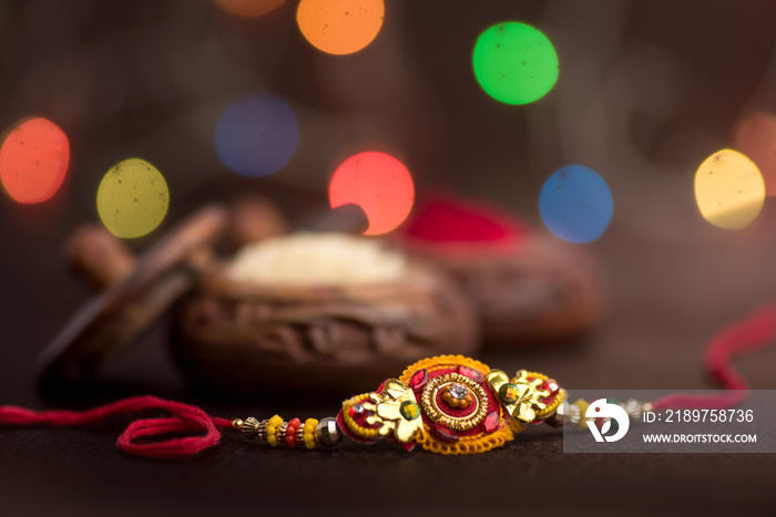 印度节日：Raksha Bandhan背景是优雅的Rakhi、Rice Grains和Kumkum。一种传统