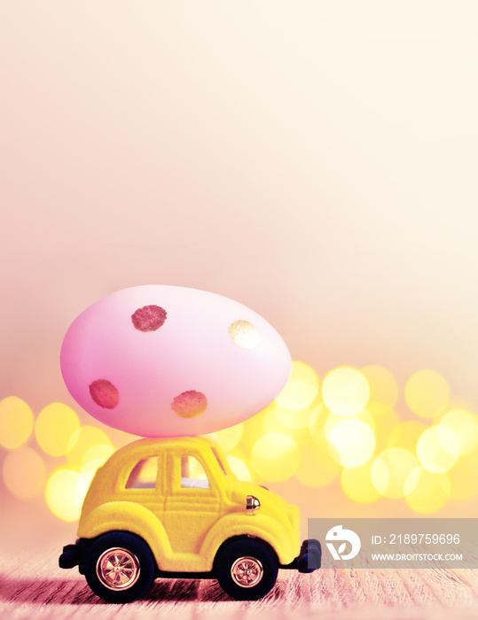 Easter egg and toy car on light bokeh background, happy easter day concept