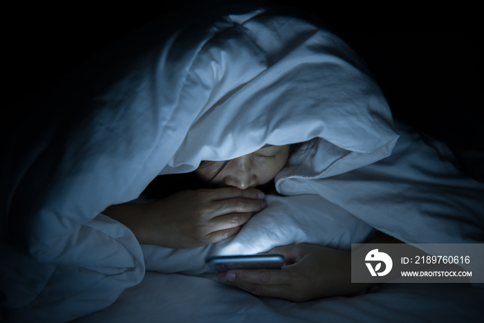 Asian woman play smartphone in the bed at night,Thailand people