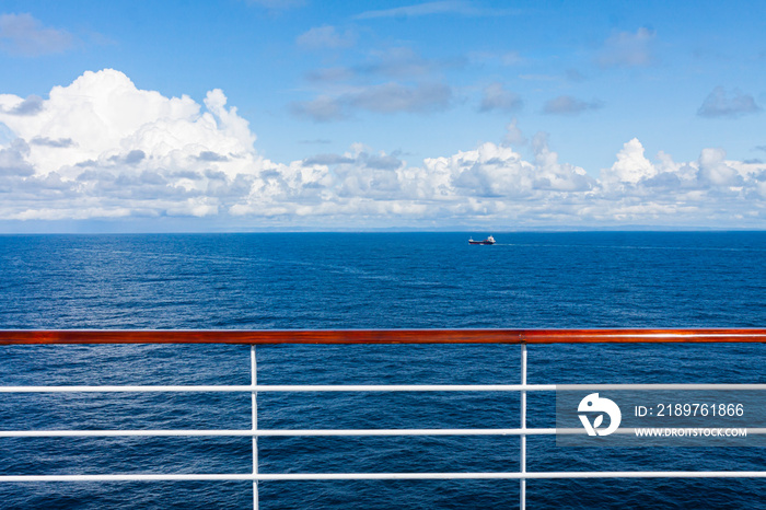 SEA LANDSCAPE FROM THE CRUISE COVER AND WOODEN RAILING IN CLOSE UP