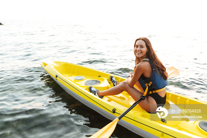 Woman kayaking on lake sea in boat.