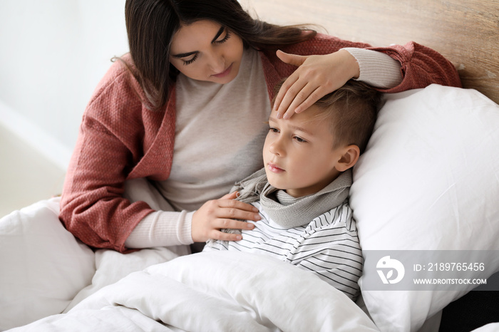 Mother taking care of his son ill with flu at home