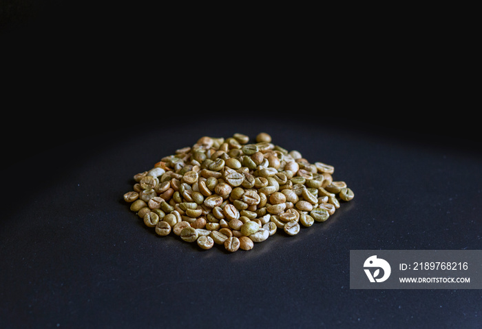 Unroasted coffee beans of the Robusta variety on a black background. Green coffee before being roast