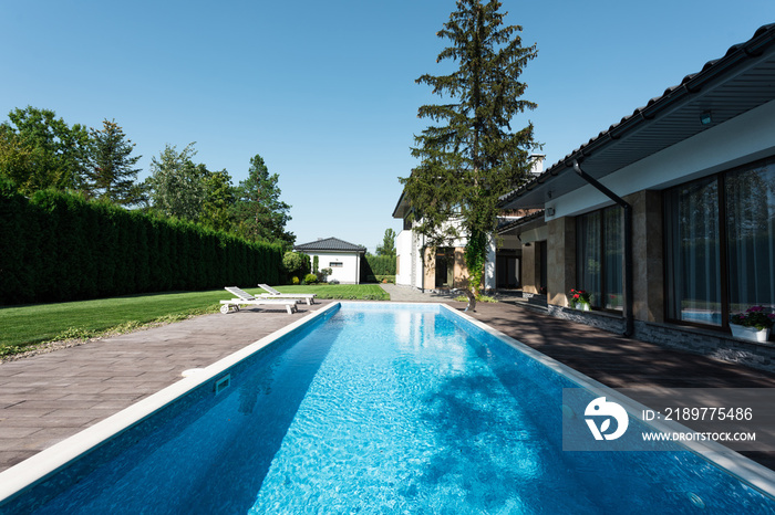 现代住宅景观，带日光浴床的游泳池