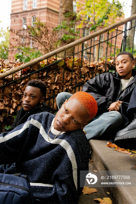 The black trans friends sat on the steps of a park.