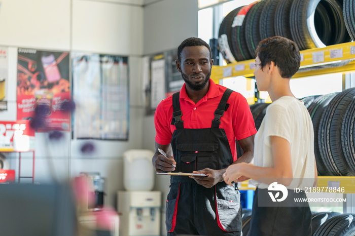 A technician provide service and talking to a customer in the auto service canter/tires service cent