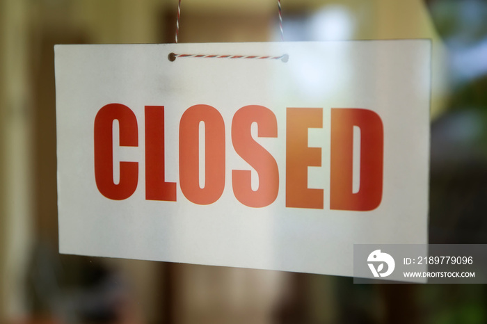 Closed sign board hanging on door of cafe or small store