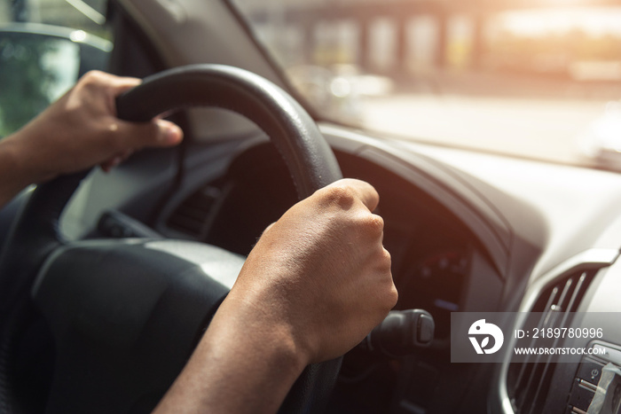 A hand pushes the cruise control button on a steering wheel