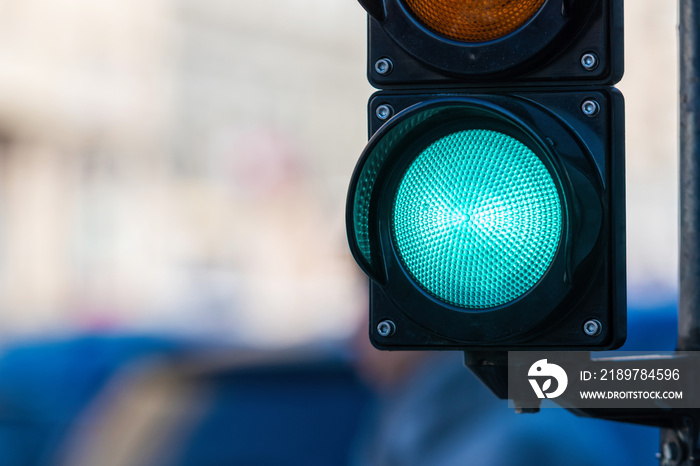 close-up of traffic semaphore with green light on defocused city street background with copy space