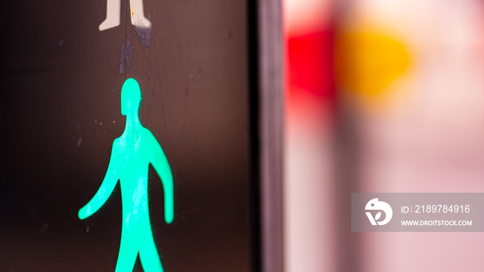 Illuminated green crossing man symbol in the UK