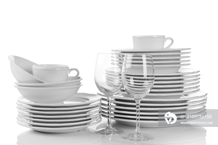 堆叠的白色干净盘子、玻璃杯和杯子隔离在白色上