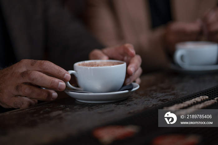 Close-up of male hands holding cup of coffee