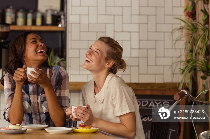 Female friends having fun while having coffee