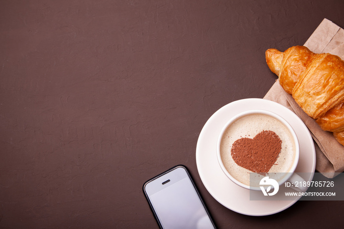 Cup of coffee with heart on the foam. I like morning coffee with  croissant
