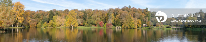 威尔特郡Stourhead花园湖泊周围秋季色彩的全景照片。