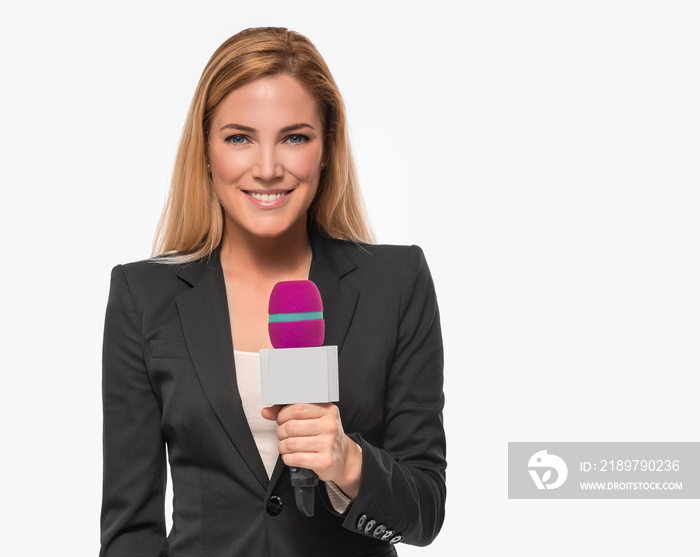 Attractive blonde TV presenter on white background holding a microphone and points to an object.