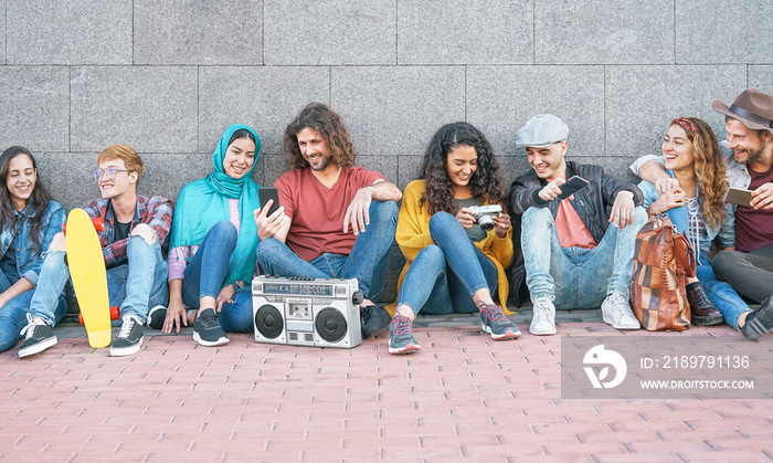 Group of diverse friends having fun outdoor - Millennial young people using mobile phones taking pho