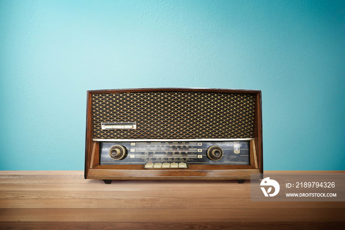 老式复古广播电台，放在薄荷蓝背景的木桌上。