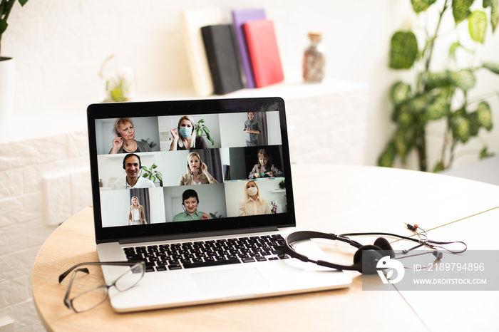 online conversation using laptop and headphones at office desk