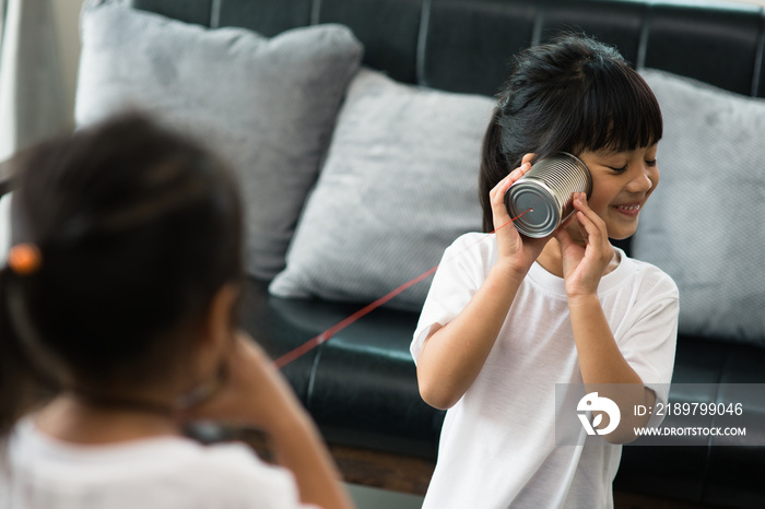 kids playing with tin can and string phone as communication concept