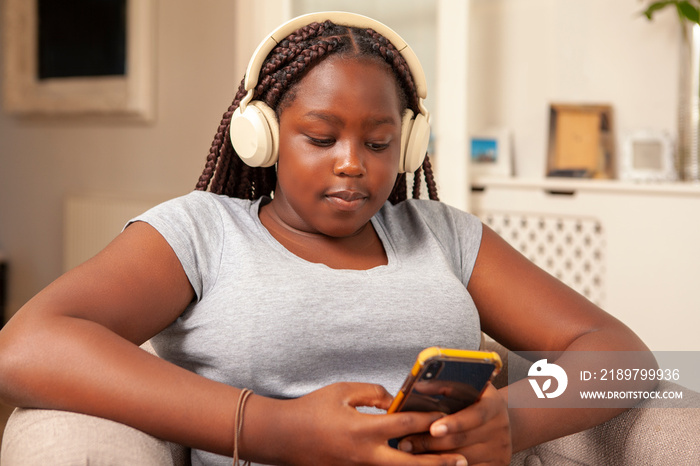 Girl in headphones using smart phone