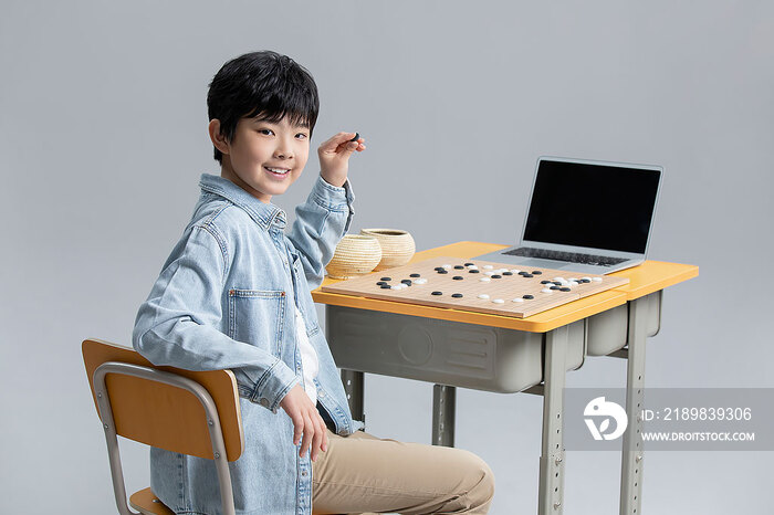 男孩上网课学习下围棋