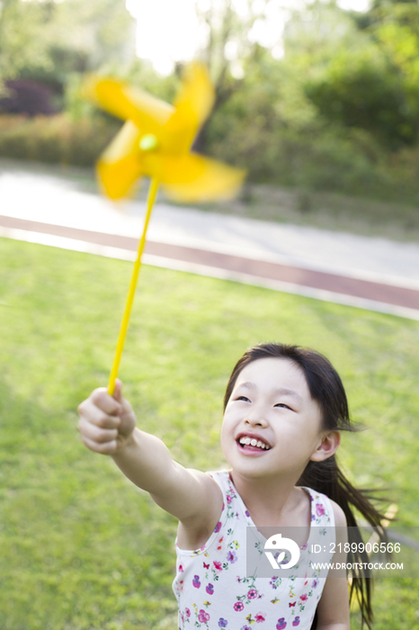 快乐的小女孩拿着纸风车玩