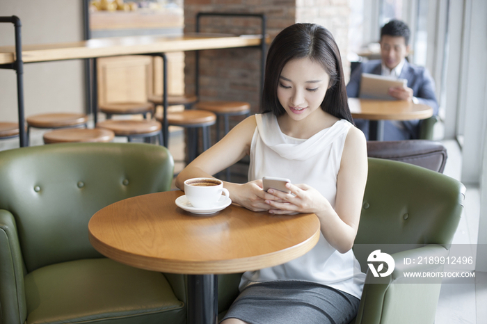 年轻女子在咖啡厅使用手机