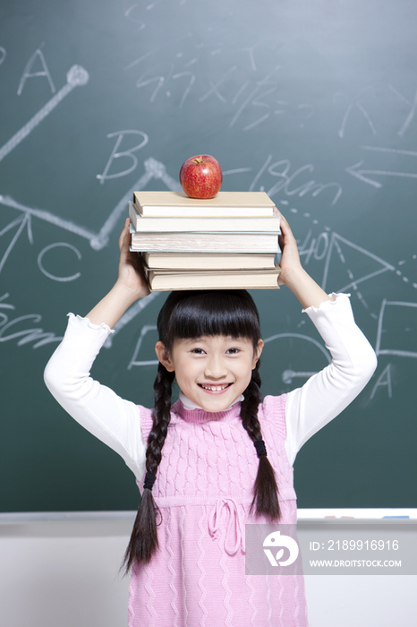 小女孩手托书本和苹果