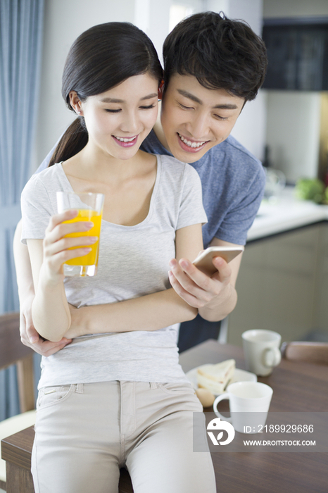 快乐的年轻夫妇在家玩手机