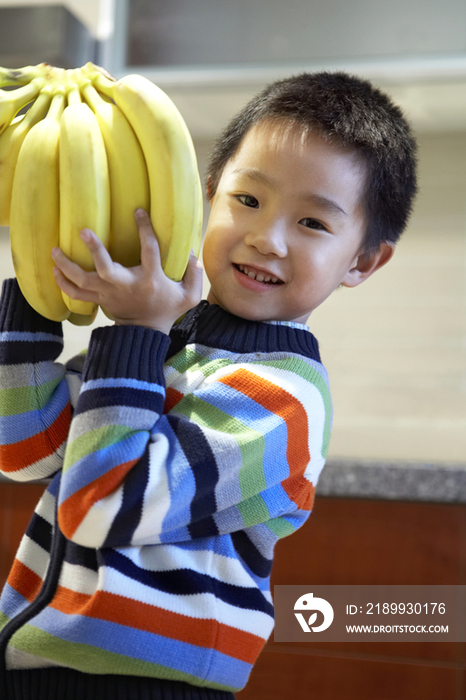 小男孩手拿香蕉