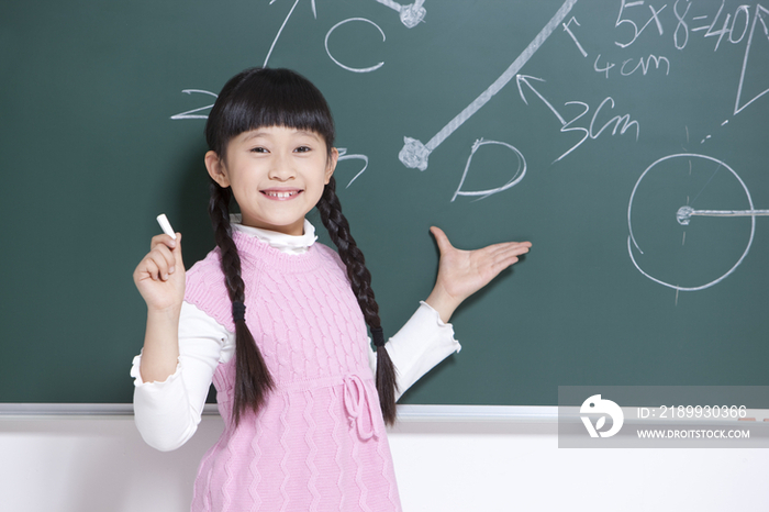 开心的小女孩在黑板上写字