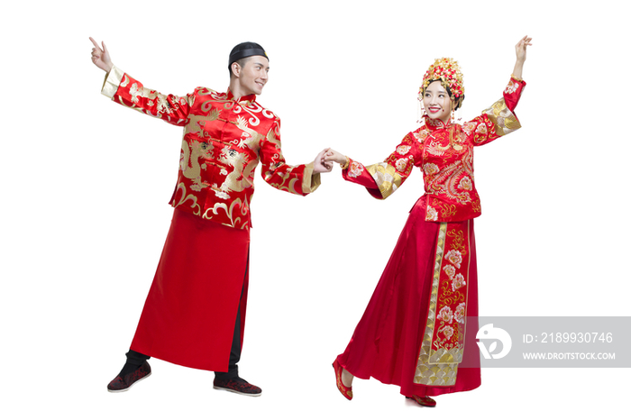 穿中式古装结婚礼服的新娘和新郎跳舞