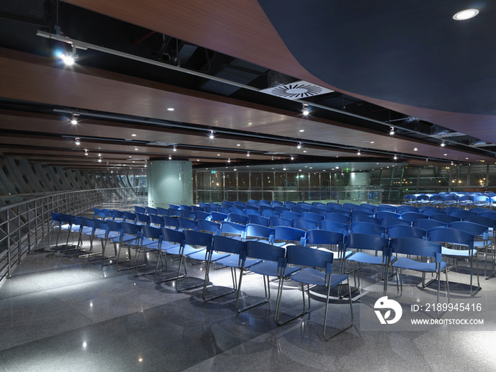 Blue chairs arranged in auditorium of shopping mall