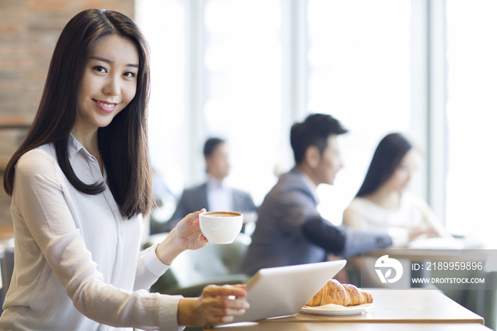 年轻女子在咖啡厅使用平板电脑