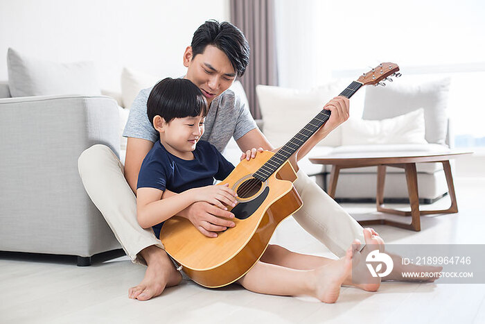年轻父亲教儿子弹吉他
