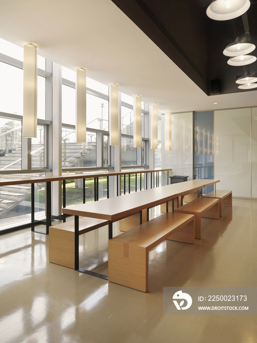 Wooden benches and empty tables by window in the restaurant