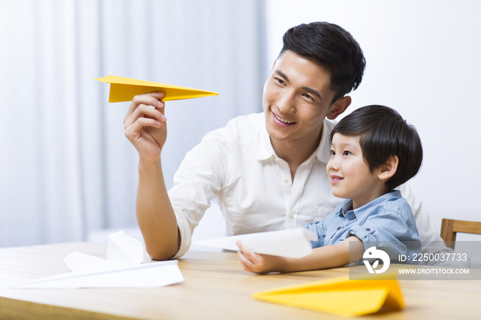 父亲和儿子一起折纸飞机