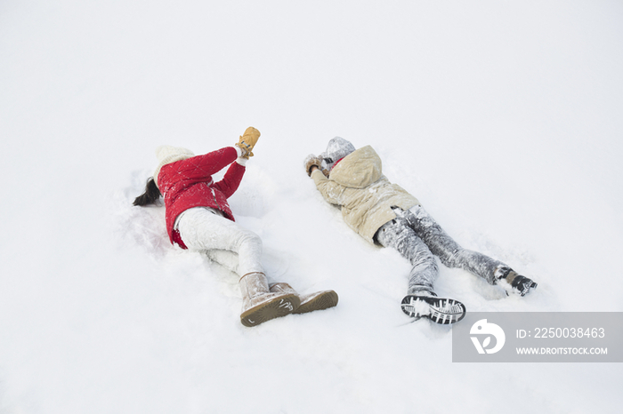 两个小孩躺在雪地上