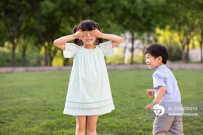 快乐的儿童在公园玩捉迷藏