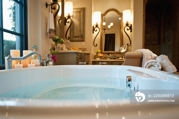 Bathtub and wall sconces in hotel bathroom