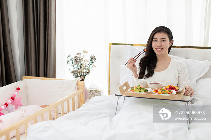产妇在床上享受月子餐