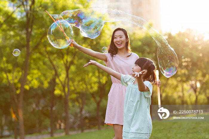 快乐的母女俩在公园玩泡泡