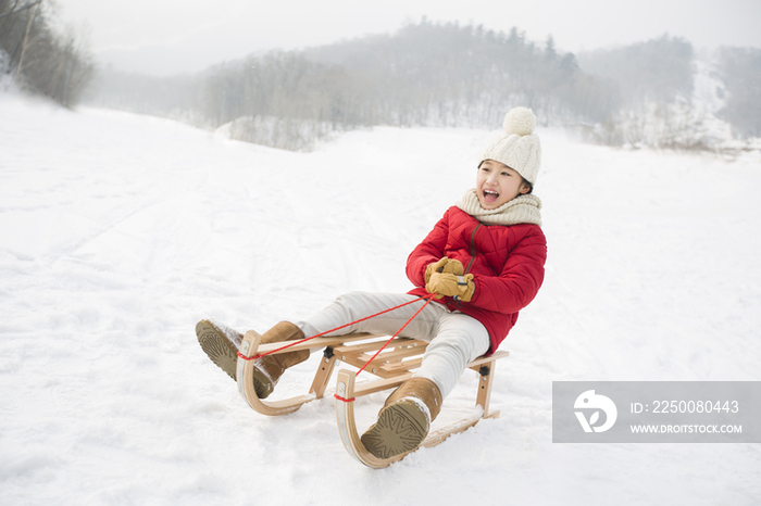 快乐的小女孩乘雪橇滑雪